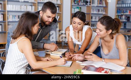 Glückliche Studenten Brainstorming in der Bibliothek Stockfoto