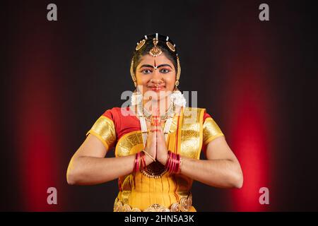 Die indische bharatanatyam-Tänzerin begrüßt sie, indem sie Namaste mit Blick auf die Kamera macht - Konzept eines traditionellen selbstbewussten Künstlers, klassischen Tanzes und Hobbykünstlers. Stockfoto