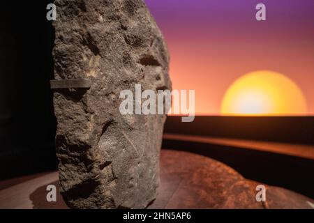 Das British Museum London, Großbritannien. 14. Februar 2022. Eine Steinschnitzerei mit einem projizierten Sonnenuntergang im Hintergrund in der Welt von Stonehenge, einer großen neuen Ausstellung im British Museum, die heute (bis 17. Juli) eröffnet wird. Über 430 Objekte aus ganz Europa wurden zusammengebracht, um die Geschichte zu erzählen und den historischen Kontext von Stonehenge zu vermitteln. Foto: Richard Gray/Alamy Stockfoto