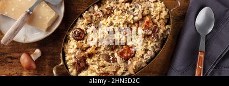 Pilzrisotto-Panorama mit Zutaten auf dunklem, rustikalem Holzhintergrund, Topshot Stockfoto