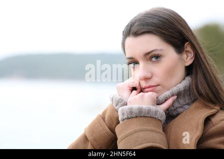 Porträt einer ernsthaften Frau, die Sie im Winter in einem See ansieht Stockfoto