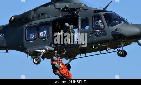 Thiene Italien, 16. OKTOBER 2021 der Helfer steigt mit einer Bahre von der Seitentür eines Militärhubschraubers herab, um eine Person zu retten und ihr Leben zu retten. Stockfoto