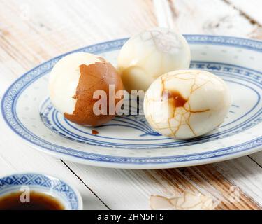 Hart gekochte chinesische marmorierte Teeeier, Vintage-Effekt auf ovaler blauer Platte Stockfoto