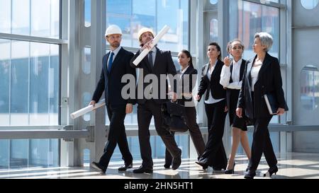 Team von Bauarbeitern Ingenieur Architekten Geschäftsleute Profis, die in der modernen Lobby zusammenlaufen Stockfoto