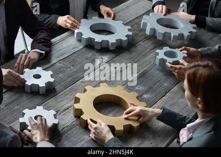 Eine Gruppe von Geschäftsleuten, die sich zusammenschließen, steht am Arbeitsplatz auf dem Tisch Stockfoto