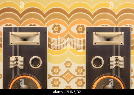 Zwei Vintage-Stereo-Lautsprecher vor Retro-Blumen-Tapeten aus den Siebzigern Stockfoto