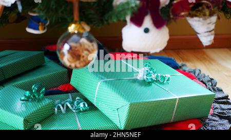 Grüne Geschenke unter dem Weihnachtsbaum platziert Stockfoto