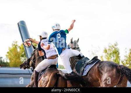 Horseball-Spiel, Adrenalin-Spiel. Zwei Spieler auf ihren Pferden kämpfen in einem Pferdeballspiel in Katalonien, Spanien, um den Ball. Rückansicht Stockfoto