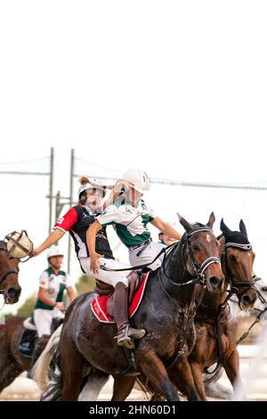 Horseball-Spiel, Adrenalin-Spiel. Zwei Spieler auf ihrem Pferd kämpfen in einem Pferdeballspiel um den Ball, Vorderansicht Stockfoto