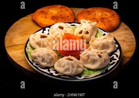 Manta Rochen mit saftigem Fleisch auf einem Teller auf einem Holztablett mit gebackenen Kuchen Stockfoto