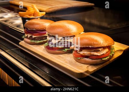 Frisch schmelzende Burger bereit, während Fast-Food-Festival zu essen. Außerhalb Dinner-Party mit Fast Food. Schmelzkäse und goldenes Brötchen. Appetitlich Nahaufnahme h Stockfoto