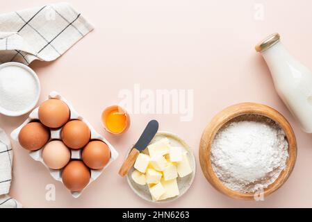 Backzutaten auf beigefarbenem Hintergrund. Mehl Eier Butter Zucker und Hafermilch, Zutaten für die Herstellung von Kuchen, Kekse oder Gebäck. Kopiespeicherplatz in der Draufsicht Stockfoto