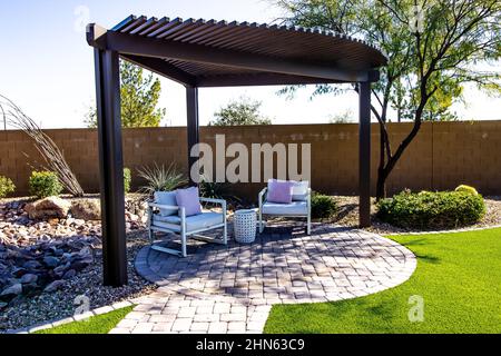 Kleiner Hinterhof Pergola Mit Zwei Stühlen Auf Der Terrasse Mit Runden Pflastersteinen Stockfoto