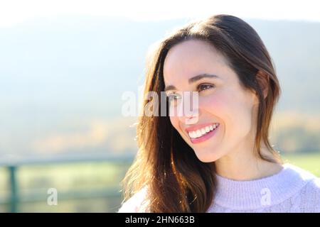 Porträt einer glücklichen Frau mit perfektem Lächeln und Blick auf die Seite im Berg Stockfoto