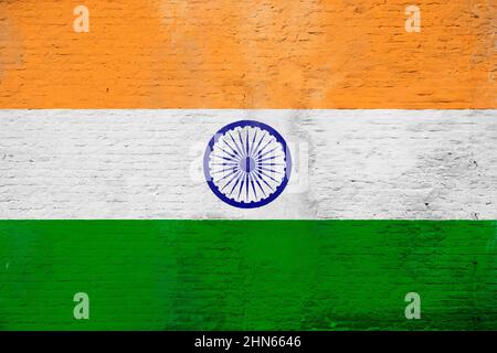 Vollformatfoto einer verwitterten Flagge Indiens, gemalt auf einer verputzten Ziegelwand. Stockfoto