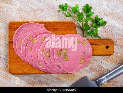 Bild von Mortadela-Wurst mit in Scheiben geschnittenen Oliven Stockfoto