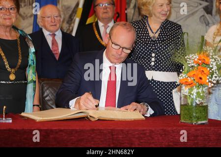 Simon Coveney signiert ein Buch als Mitglied einer irischen diplomatischen Delegation bei einem Besuch in Würzburg Stockfoto