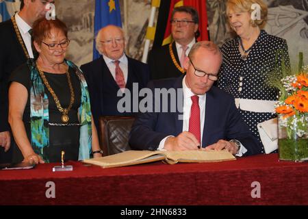 Simon Coveney signiert ein Buch als Mitglied einer irischen diplomatischen Delegation bei einem Besuch in Würzburg Stockfoto