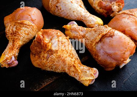 Rohe Chicken Drumsticks, in Gewürze gerieben: Ungekochte Hühnerbeine, bestäubt mit Paprika und anderen Gewürzen Stockfoto