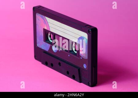 Vintage-Audiokassette perspektivisch isoliert. Rosa Hintergrund. Warmes Licht Stockfoto