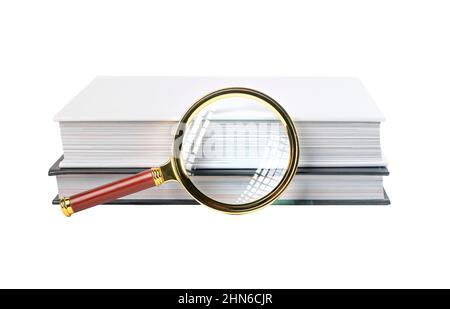Bücher stapeln mit Lupe isoliert auf weißem Hintergrund. Textsuche und -Analyse-Konzept. Hochwertige Fotos Stockfoto