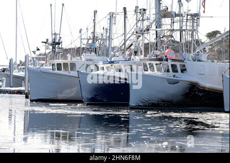 Eine Reihe kommerzieller Fischerboote an einem Wintertag in Saquatucket Harbour, Harwich, Massachusetts, USA Stockfoto