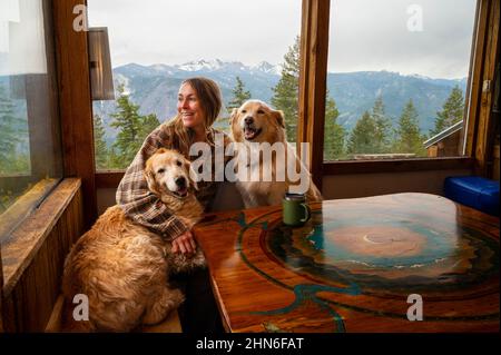 Hündin mit Hunden beim Kaffee in einer Berghütte Stockfoto