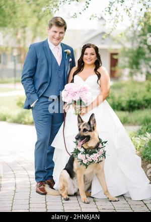 Braut und Bräutigam mit Schäferhund am Hochzeitstag Stockfoto