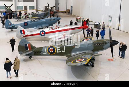IWM Duxford Imperial war Museum - Menschen, die spitfire-Kampfflugzeuge in einem Hangar betrachten, Duxford Air Museum, Cambridgeshire England Großbritannien