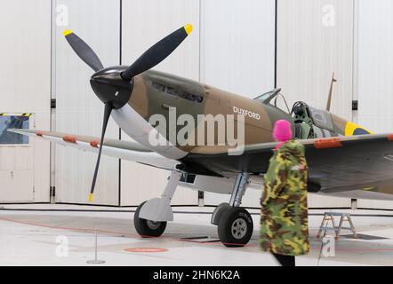 UK Museum; Imperial war Museum Duxford; eine Frau, die ein Spitfire Mk1 WW2 Kampfflugzeug anschaut, IWM Duxford Interior, Duxford, Cambridgeshire UK Stockfoto