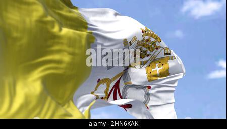 Detail der Nationalflagge des Vatikans, die an einem klaren Tag im Wind winkt. Religion und Politik. Selektiver Fokus. Stadtstaat in Rom, Italien Stockfoto