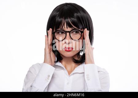 Schwarz haarige Frau in schwarzen Brillen mit roten Lippen tragen weißes Hemd mit Emotionen des Misstrauens oder Kopfschmerzen. Stockfoto