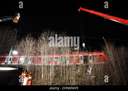 14. Februar 2022, Bayern, Schäftlarn: Am Unfallort ist ein Kran im Einsatz. Bei einem Zusammenstoß zweier Nahverkehrszüge im Münchner Bezirk wurde am Montag eine Person getötet und mehr als zehn verletzt. Es gebe eine niedrige zweistellige Zahl von Verletzten, berichtete ein Sprecher des Münchner Polizeipräsidals. Foto: Matthias Balk/dpa Stockfoto