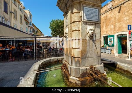 Brunnen auf dem kleinen Stadtplatz unter Restaurants im Freien in der Altstadt von Antibes - Stadt an der französischen Riviera. Stockfoto