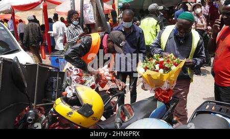 Nairobi, Kenia. 14th. Februar 2022. Ein Lieferer bereitet sich darauf vor, am Valentinstag in Nairobi, der Hauptstadt Kenias, am 14. Februar 2022 Blumensträuße außerhalb eines Blumenmarktes zu liefern. Der Blumenmarkt ist überfüllt mit Kunden sowie Lieferern versuchen, die Lieferung pünktlich am Valentinstag zu bekommen. Quelle: Shi Yu/Xinhua/Alamy Live News Stockfoto