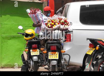 Nairobi, Kenia. 14th. Februar 2022. Ein Lieferer bereitet sich darauf vor, am Valentinstag in Nairobi, der Hauptstadt Kenias, am 14. Februar 2022 Blumensträuße außerhalb eines Blumenmarktes zu liefern. Der Blumenmarkt ist überfüllt mit Kunden sowie Lieferern versuchen, die Lieferung pünktlich am Valentinstag zu bekommen. Quelle: Shi Yu/Xinhua/Alamy Live News Stockfoto