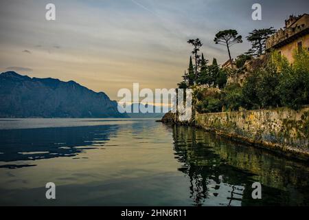 Winter am Gardasee, gesehen von Malcesine in der Provinz Verona, Venetien, Nordostitalien. Die Crenelationen von der Burg Malcesine sind im Hintergrund rechts Stockfoto