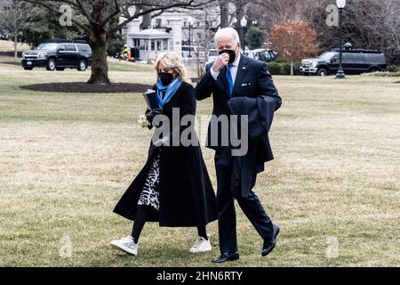 Washington, Usa. 14th. Februar 2022. Präsident Joe Biden und First Lady Jill Biden gehen auf dem South Lawn zum Südportikus des Weißen Hauses, nachdem sie über Marine One dorthin zurückgekehrt sind. Kredit: SOPA Images Limited/Alamy Live Nachrichten Stockfoto