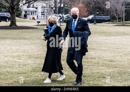 Washington, Usa. 14th. Februar 2022. Präsident Joe Biden und First Lady Jill Biden gehen auf dem South Lawn zum Südportikus des Weißen Hauses, nachdem sie über Marine One dorthin zurückgekehrt sind. Kredit: SOPA Images Limited/Alamy Live Nachrichten Stockfoto