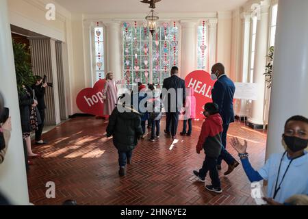 Washington, USA. 14th. Februar 2022. DIE US-amerikanische First Lady Jill Biden spaziert mit Schülern der zweiten Klasse der Aiton Elementary School im Ostflügel, während sie sich am 14. Februar 2022 im Weißen Haus in Washington, DC, die Kunstwerke zum Valentinstag ansehen. (Foto von Oliver Contreras/Pool/Sipa USA) Quelle: SIPA USA/Alamy Live News Stockfoto