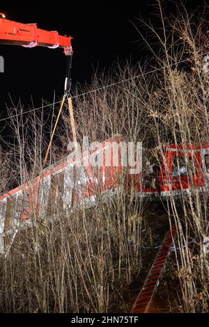 14. Februar 2022, Bayern, Schäftlarn: Am Unfallort ist ein Kran im Einsatz. Bei einem Zusammenstoß zweier Nahverkehrszüge im Münchner Bezirk wurde am Montag eine Person getötet und mehr als zehn verletzt. Es gebe eine niedrige zweistellige Zahl von Verletzten, berichtete ein Sprecher des Münchner Polizeipräsidals. Foto: Matthias Balk/dpa Stockfoto