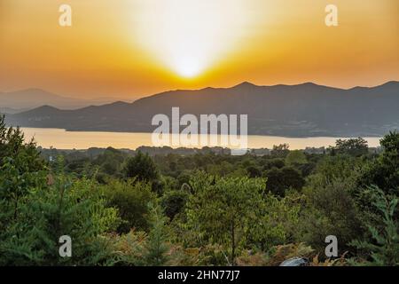 Blick auf den künstlichen See Polyfytos und das Dorf Velventos bei Sonnenuntergang. Larissa, Griechenland. Stockfoto