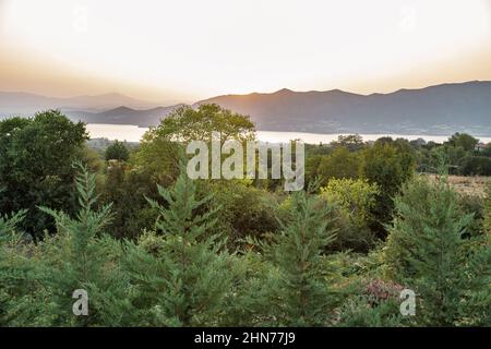 Blick auf den künstlichen See Polyfytos und das Dorf Velventos bei Sonnenuntergang. Larissa, Griechenland. Stockfoto