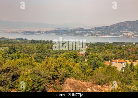 Blick am Morgen auf den künstlichen See Polyfytos, die Brücke Servia Neraida und das Dorf Velventos. Larissa, Griechenland. Stockfoto