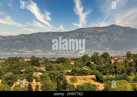 Blick am Morgen auf den künstlichen See Polyfytos, die Brücke Servia Neraida und das Dorf Velventos. Larissa, Griechenland. Stockfoto