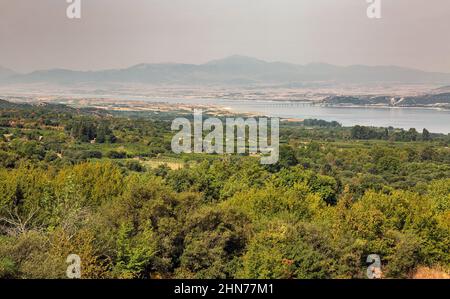 Blick am Morgen auf den künstlichen See Polyfytos, die Brücke Servia Neraida und das Dorf Velventos. Larissa, Griechenland. Stockfoto