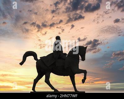 Silhouette der Statue von Carol I., dem ersten König des modernen Rumäniens, gegen einen dramatischen Sonnenuntergang in Bukarest Stockfoto