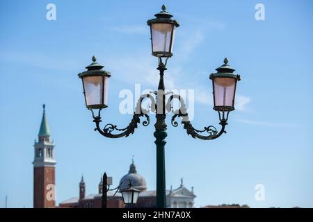 Traditionelle Beleuchtung am Wasser mit dem Campanile di San Marco im Hintergrund Stockfoto
