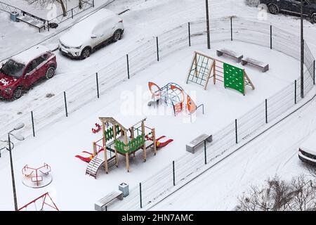 Kinderspielplatz in der Wintersaison, eine mit Schnee bedeckte Ausrüstung, Blick von über Stockfoto