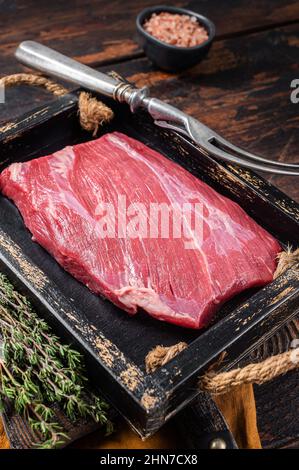 Grass Fed Roh Flanke Rindfleisch Fleischsteak in Holzschale mit Kräutern. Holzhintergrund. Draufsicht Stockfoto